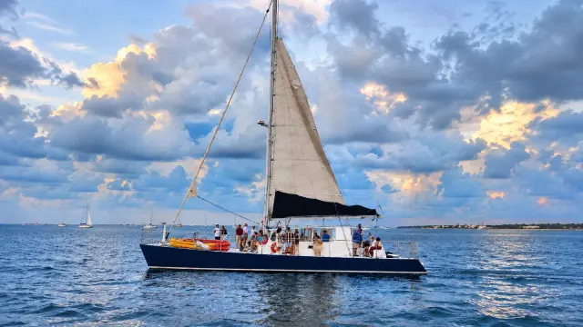 Sailing catamaran under blue sky and golden clouds off Key West