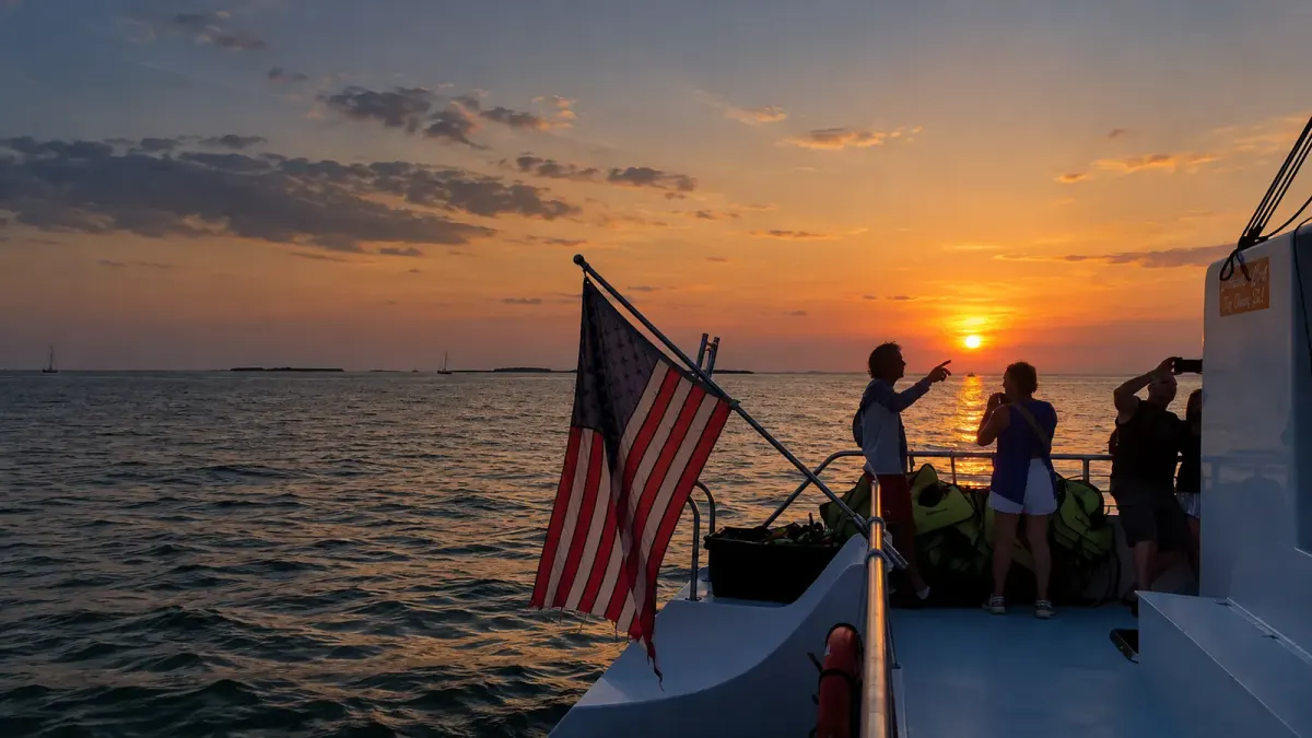 Guests at the stern with an American flag watching the sun set over the water